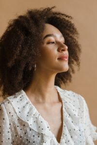 Portrait of a confident woman with afro hair wearing a polka dot blouse, exuding natural beauty and empowerment.